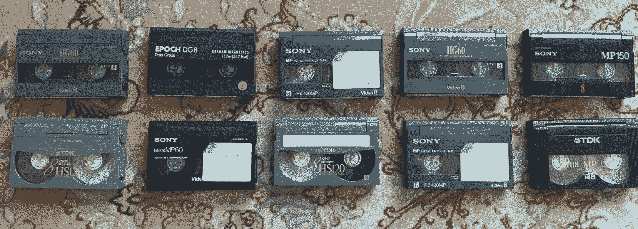 photo of eight Video8 tapes in two rows atop a pink Tabrizi rug