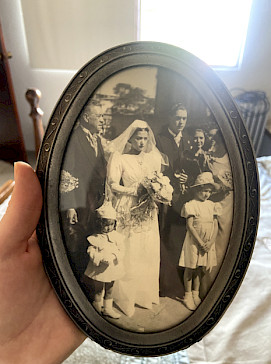 An old, round, framed photo of two people getting married.