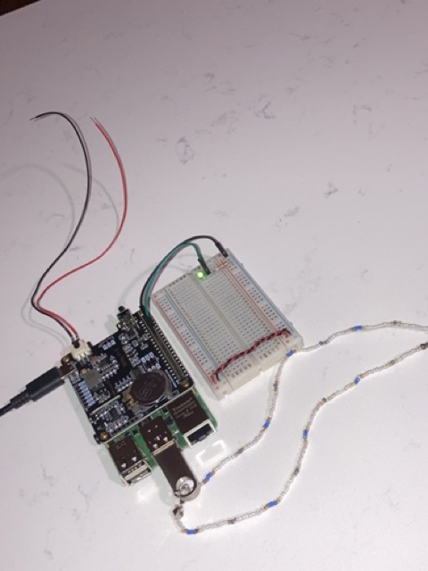 A small electronics project setup with a microcontroller board connected to a breadboard and several wires.